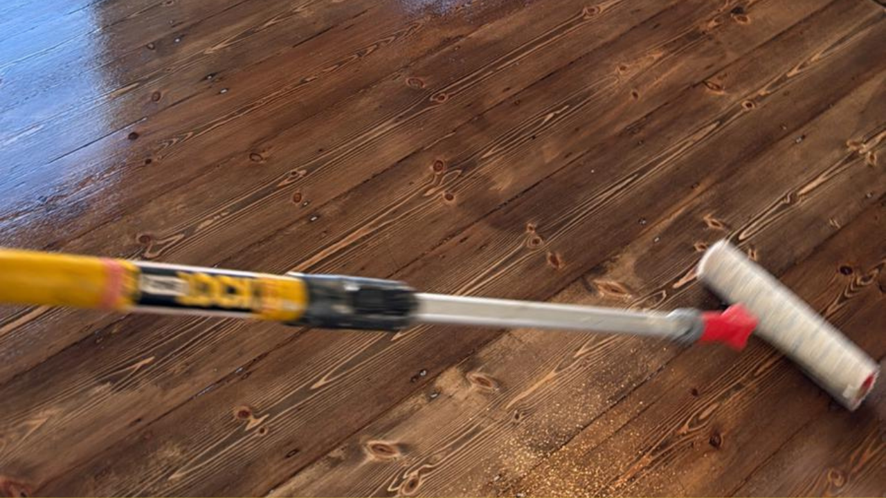 Applying finish to restored pine floorboards after expert wood floor sanding in a Catford property.