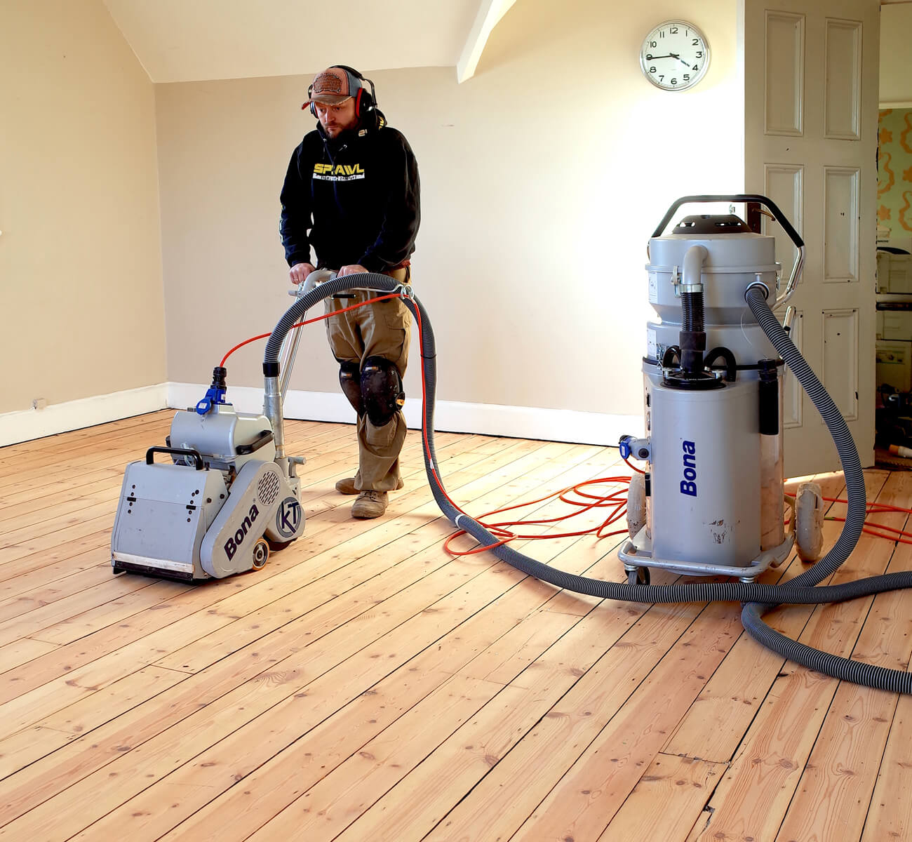 Professional using dust-free equipment for expert wood floor sanding on solid pine flooring in Catford.