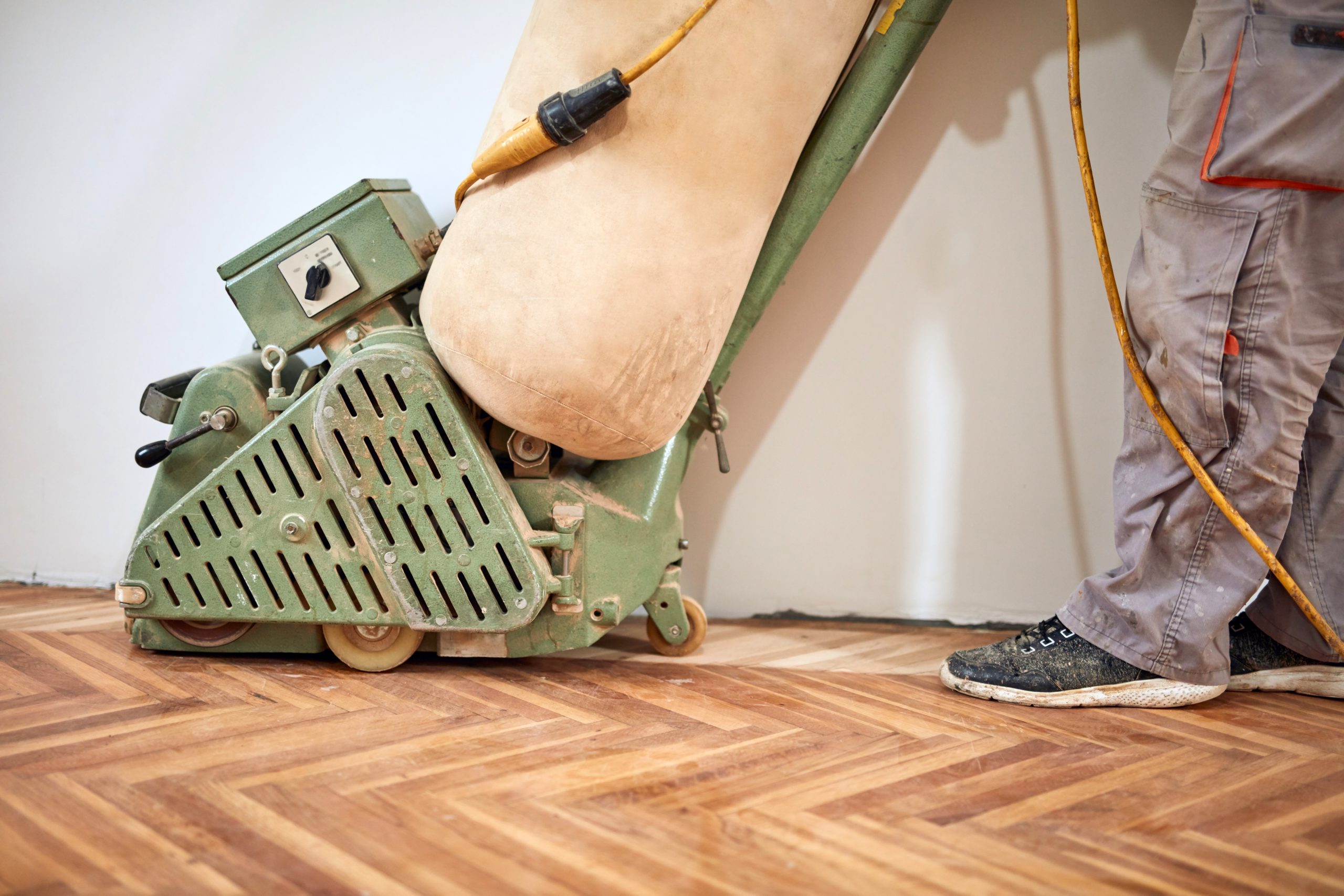 Drum sanding machine being used on herringbone parquet flooring during a professional wood floor sanding project in Catford.