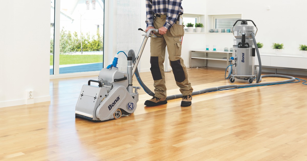 Pub Refurbs in Catford – dust-free sanding of an oak hardwood plank floor using a Bona belt sander with HEPA extraction, prepping the bar area for sealing.