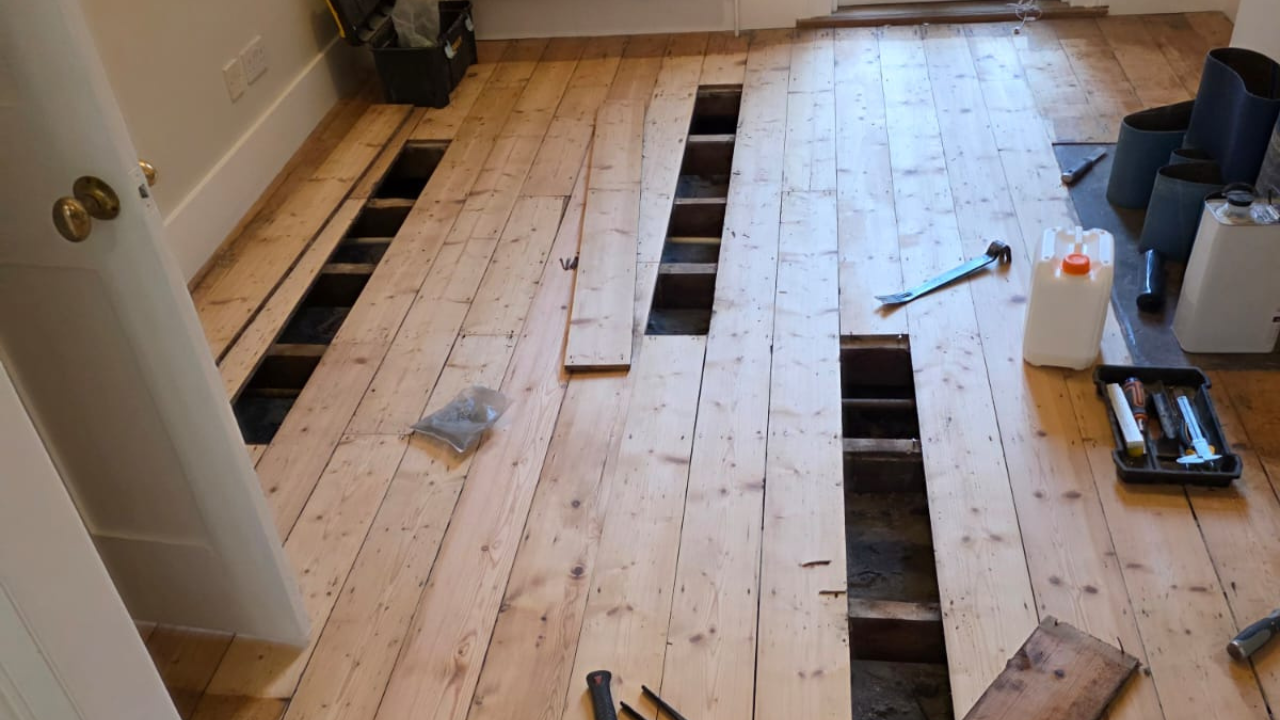 Wood Floor Sanding in Catford with pine softwood floorboards lifted for subfloor repairs before restoration.