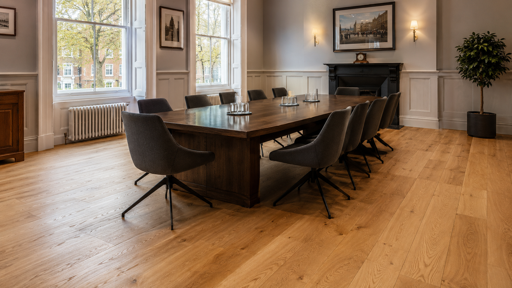 Restored light oak timber boardroom floor in a professional Catford SE6 meeting room, featuring a large dark wood conference table and grey upholstered chairs with natural daylight from tall windows.